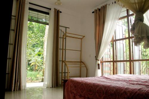 een slaapkamer met een bed en een groot raam bij The Breeze Pinnawala in Pinnawala