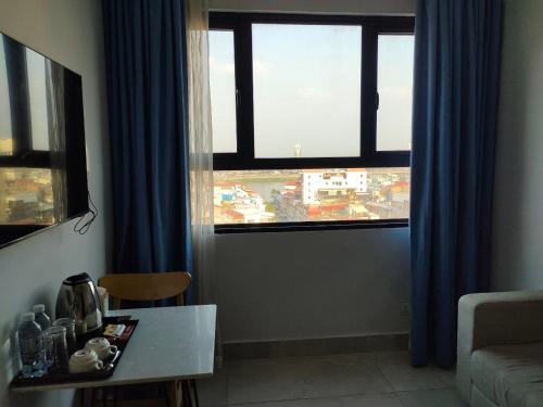 een woonkamer met een tafel en 2 ramen bij Residence 110 (Hotel and Apartments) in Phnom Penh