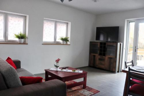 uma sala de estar com um sofá e uma mesa em Mohnblume em Großrinderfeld