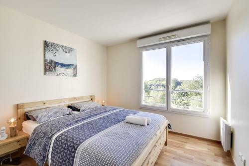 a bedroom with a bed and a window at Chic apart avec terrace et parking in Cergy