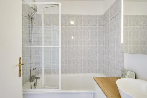 a bathroom with a shower and a bath tub at Chic apart avec terrace et parking in Cergy