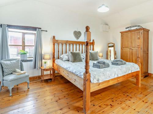una camera con letto in legno e sedia di 3 Bed in Gower 93942 a Ilston