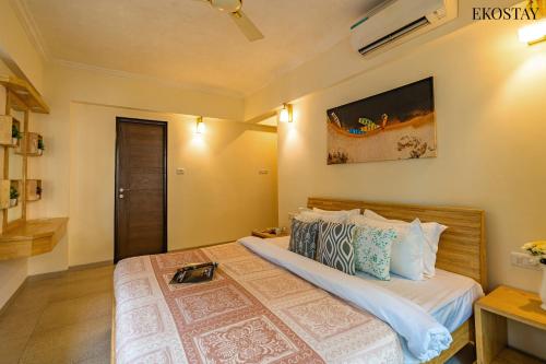 a bedroom with a large bed in a room at EKO STAY - Woodlock Apartment in Candolim