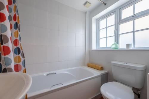 a bathroom with a tub and a toilet and a sink at Sea Haven in Wells next the Sea