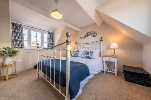 a bedroom with a bed with a blue blanket at Sea Haven in Wells next the Sea