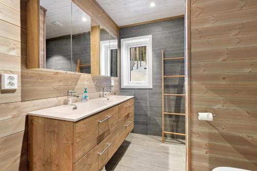 uma casa de banho com um lavatório e um espelho em Moderne hytte met eindeloos uitzicht en een sauna em Vradal