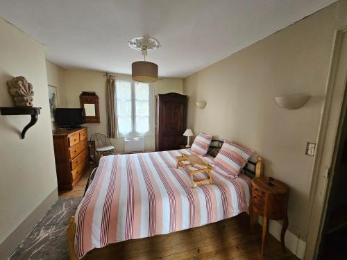 1 dormitorio con 1 cama con sábanas de rayas y TV en NIGHT & DAY, en Honfleur