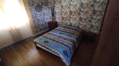 małe łóżko w pokoju ze ścianą w obiekcie maison grand parking w mieście Tournon-Saint-Martin
