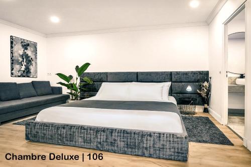 une chambre avec un grand lit et un canapé dans l'établissement MAYA Appartements & Suites, à Cosne Cours sur Loire