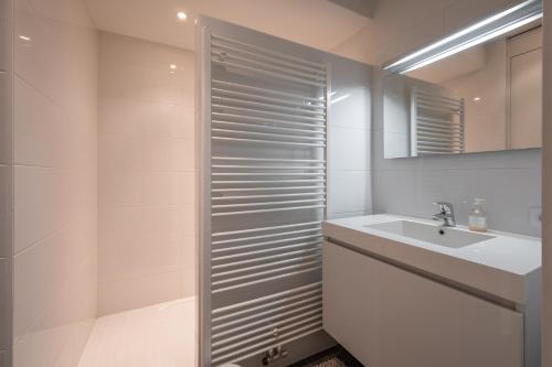 bagno bianco con lavandino e doccia di Beautiful beach-appartment between Knokke & Bruges a Zeebrugge