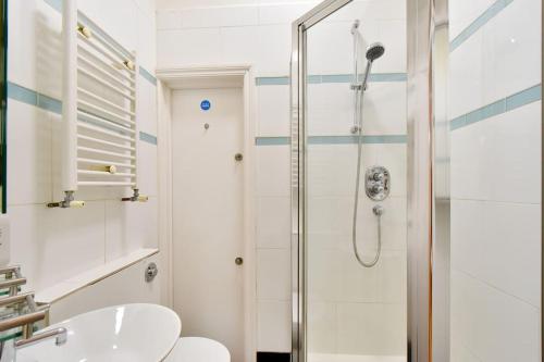 y baño con ducha, aseo y lavamanos. en Split Level 3 Bed- Hyde Park, en Londres
