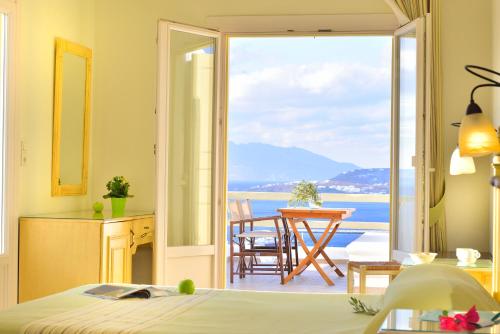 a bedroom with a bed and a view of the ocean at Pelican Hotel in Mýkonos City