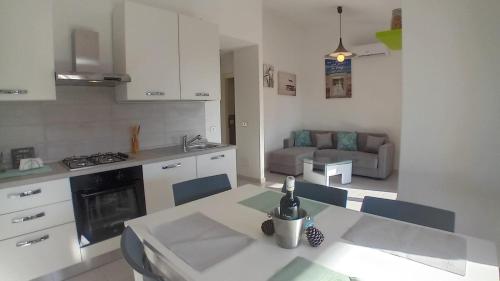 cocina y sala de estar con mesa y sofá en Appartamenti Cala del Sole - INFINITYHOLIDAYS en Costa Paradiso