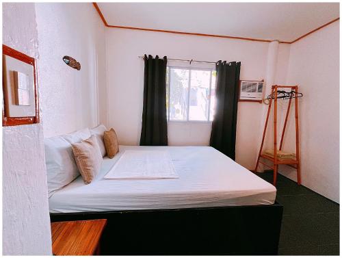 a bed in a room with a window at Everyday Sunday Hotel & Cafe in Bantayan Island