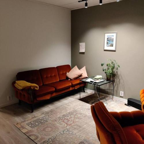 Nybygget leilighet i Kabelvåg في كابلفونغ: غرفة معيشة مع أريكة بنية وطاولة