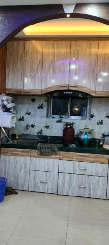 cocina con armarios de madera y encimera en Shyam appartment, en kolkata