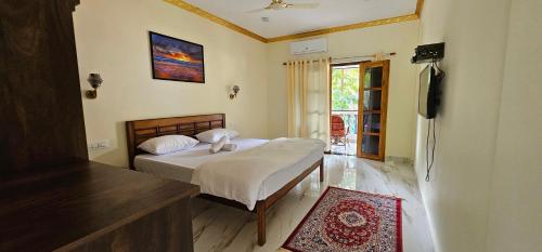 een slaapkamer met een bed en een televisie in een kamer bij Divine Kingdom at Abba's Agonda in Agonda