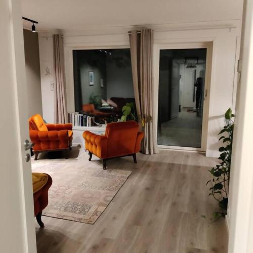 卡伯爾沃格的住宿－Nybygget leilighet i Kabelvåg，客厅配有两把椅子和一张沙发
