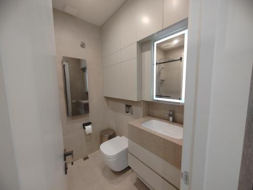 Baño blanco con aseo y lavamanos en Luxurious Intimacy Hideaway - Self Check in, en Ereván