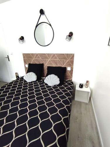 une chambre avec un lit noir et blanc et une lampe dans l'établissement résidence hyper centre parking indigo inclus à 50m, à Dieppe