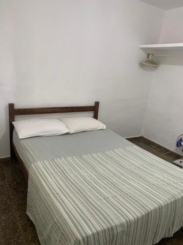 a bedroom with a bed with a striped bedspread at Casa na praia do centro in Marataizes
