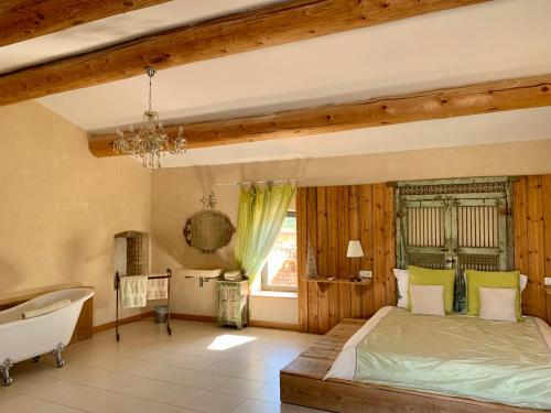 VézénobresにあるMas Des Terres Rougesのベッドルーム1室(ベッド1台、バスタブ、窓付)