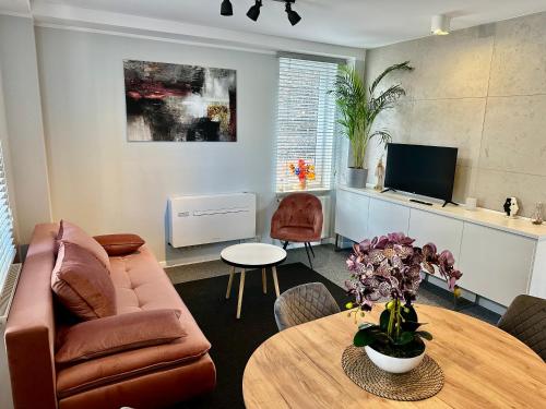 ein Wohnzimmer mit Sofa und Tisch in der Unterkunft Apartamenty 1 maja 94 Katowice, Free Parking in Kattowitz