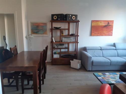 Una sala de estar con una mesa y un sofá azul. en Casa Caravaggio, en Casalecchio di Reno