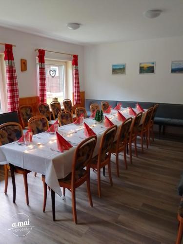 a room with tables and chairs with red napkins on them at Harzklub Wanderheim in Wildemann