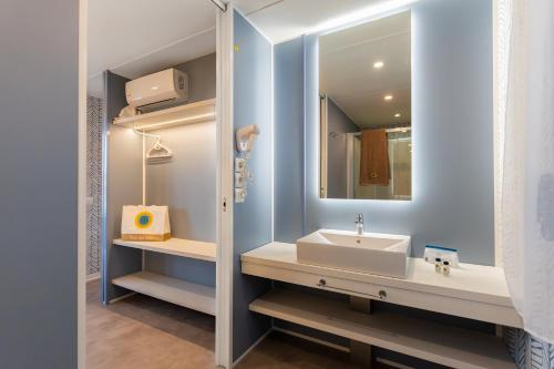 a bathroom with a sink and a mirror at Club del Sole Romagna Family Resort in Riccione