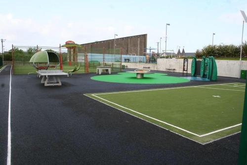 um parque com um parque infantil com um campo de ténis em Barber’s hall town center apartment em Belmullet