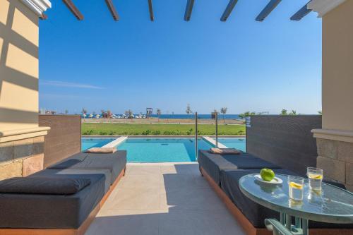 a patio with a table and a swimming pool at Lindos Imperial Resort & Spa in Kiotari