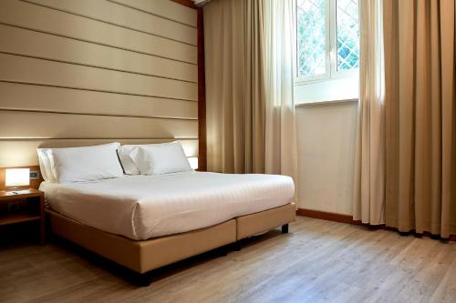 a bedroom with a bed and a window at Occidental Aurelia in Rome
