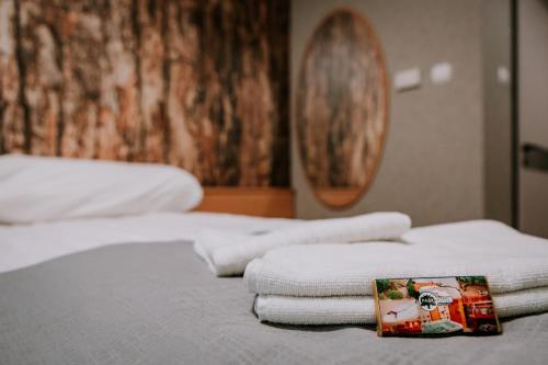 a pile of towels sitting on top of a bed at Park Hotel Sóstó in Nyíregyháza