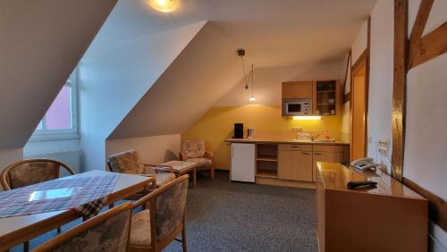 a small kitchen and dining room with a table and chairs at Hotel Peenebrücke in Wolgast