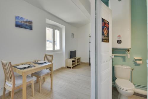 La salle de bains est pourvue d'une table, de toilettes et d'un bureau. dans l'établissement Studio au cœur du Panier proche Vieux-Port, à Marseille