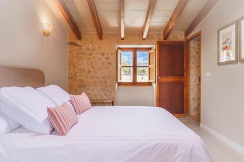 een slaapkamer met een wit bed en een raam bij Casa Fútbol in Sóller