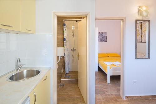 a kitchen with a sink and a bed in a room at Royal Garden Apartments & Gastronomy in Budva