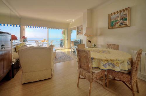 une salle à manger avec une table et des chaises avec vue sur l'océan dans l'établissement Magnifique appartement avec vue mer A2B99, à Cannes
