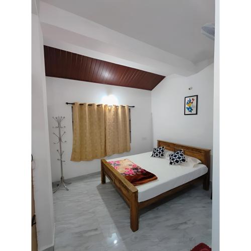 ein Schlafzimmer mit einem Bett in einem Zimmer in der Unterkunft Misty Homes in Madikeri