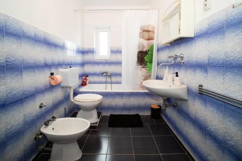 Un baño con dos inodoros, un lavabo y una bañera. en Apartments Vala, en Betina