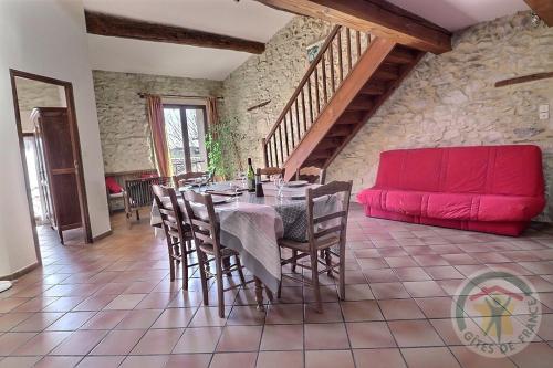 - une salle à manger avec une table et un canapé rouge dans l'établissement Mas des Esclots, à Nîmes