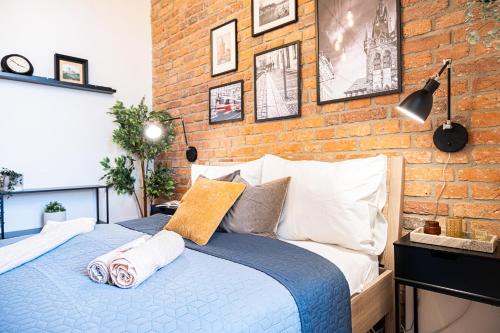 een slaapkamer met een bakstenen muur en een bed bij Cozy Industrial 8min Dancing House APT in Praag