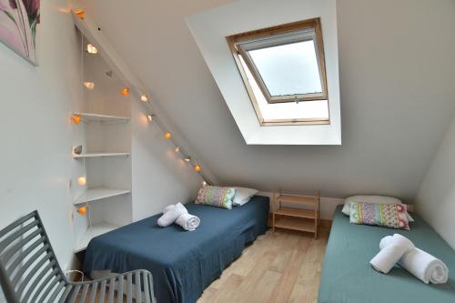 um quarto no sótão com 2 camas e uma janela em Landes - Appartement vue mer à 150m de la plage em Saint-Cast-le-Guildo