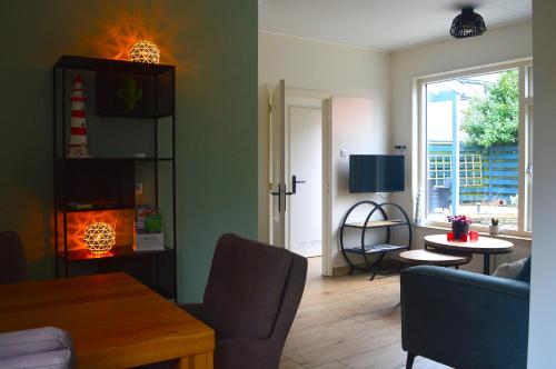 een woonkamer met een bank en een tafel bij Vakantiehuisje Te Gast op Texel in Den Burg