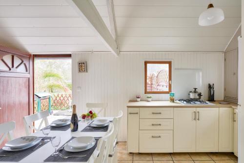 a kitchen with a table and chairs and a kitchen with white cabinets at À 800m de la plage, chalet cosy pour 4 in Loctudy