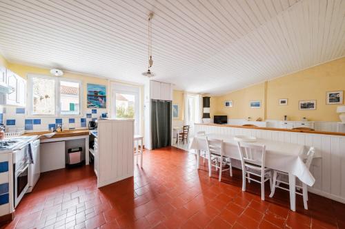 une cuisine et une salle à manger avec une table et des chaises dans l'établissement La Grange Bleue - Parking privé - A 2km de la mer, à Saint-Georges-dʼOléron