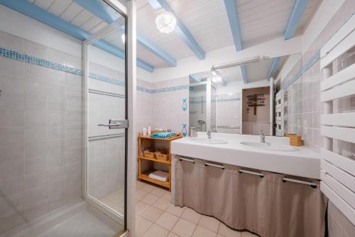 a bathroom with a sink and a shower and a mirror at La petite Grange - Parking privé - A 2km de la mer in Saint-Georges-dʼOléron