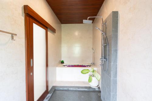 a bathroom with a shower with a plant in it at Oka Suite Sebatu Ubud in Tampaksiring