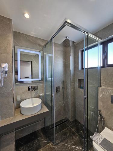 ein Bad mit einem Waschbecken und einer Dusche in der Unterkunft Adele Hotel Ksamil in Ksamil